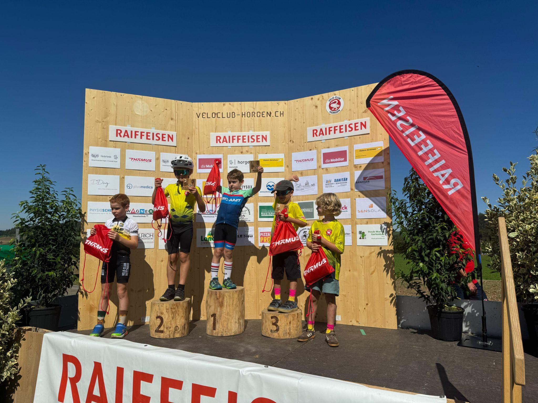 Kinder mit Preisen auf dem Podest beim Raiffeisen KidzBike Race Horgen 2026 auf dem Hirzel.